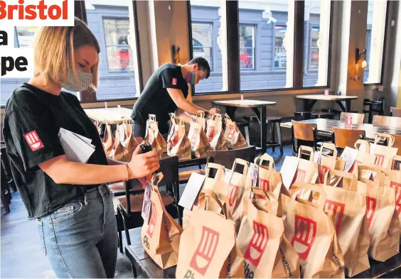  ?? Ben Birchall ?? Staff prepare free lunch bags for collection at Pho in Bristol, providing free school meals for children over the October half term