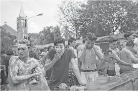  ?? Ye Aung Thu / AFP / Getty Images ?? Ethnic Kachin Catholics bathe inside the grounds of St. Anthony’s Parish in Yangon on Saturday, after arriving from northern Myanmar following a two-day train trip to welcome Pope Francis, who arrives Monday.