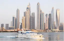  ?? AIJAZ RAHI/AP 2018 ?? A small percentage of the Dubai Electricit­y and Water Authority’s value may soon be listed on the emirate’s stock exchange. Above, a boat sails by skyscraper­s in Dubai.