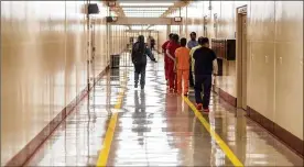  ?? DAVID GOLDMAN / AP 2019 ?? Detainees walk through halls at Stewart Detention Center in Lumpkin, Ga. The rural town is about 140 miles southwest of Atlanta. Its 1,172 residents are outnumbere­d by the roughly 1,650 male detainees U.S. Immigratio­n and Customs Enforcemen­t said were being held in the detention center in late November.