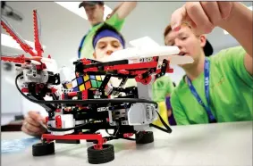  ?? NWA Democrat-Gazette/DAVID GOTTSCHALK ?? Paul Tribble (from right), 13, Caden McHaney, 13, and Hunter Keen, 17, monitor their Lego Mindstorms computer Friday during the Young Manufactur­ers Academy at Northwest Technical Institute in Springdale. The computer was able to solve a Rubik’s Cube. NTI’s Business and Industry unit received a $5,000 grant to offer the academy for a second year. Students received lessons in welding, used 3-D printers and toured Kawneer as part of the activities.