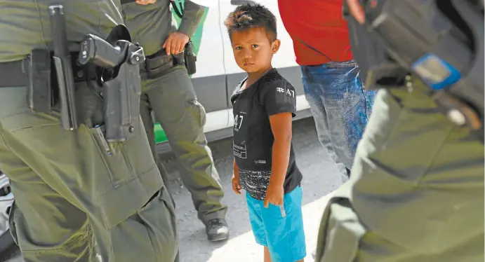  ??  ?? A Honduran boy and his father are taken into custody by US Border Patrol agents in Texas near the Mexican border last week.