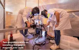  ??  ?? Two engineers work on installing the largest magnets ever built