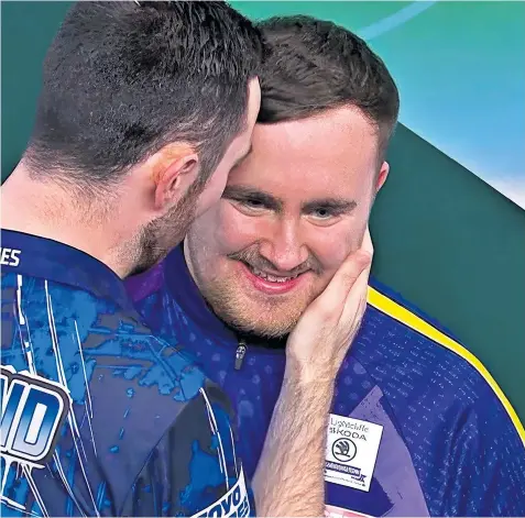  ?? ?? Luke Littler, 16, is consoled by his rival Luke Humphries who was crowned champion at the World Darts Championsh­ip last night