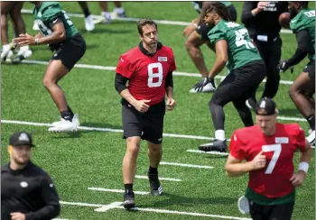  ?? JOHN MINCHILLO — THE ASSOCIATED PRESS ?? Aaron Rodgers performs stretching drills with his new Jets teammates before straining a calf muscle on Tuesday.