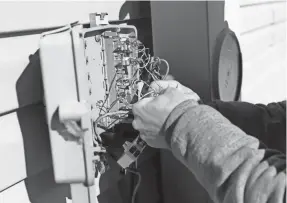  ?? SARAH KLOEPPING/USA TODAY NETWORK-WISCONSIN ?? Craig Wallace, outside plant technician with Nsight, works on an internet installati­on on Feb. 12, 2021, in rural Oconto County just north of Pulaski.