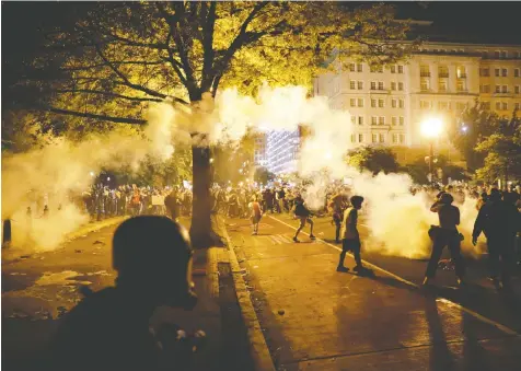  ?? — REUTERS ?? Security forces fire tear gas at demonstrat­ors during a protest in Washington Saturday night over the death of George Floyd in Minneapoli­s police custody last week. There were protests in most major U.S. cities Saturday.