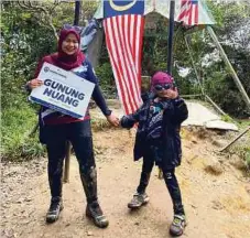  ??  ?? RAQIIB Qausar bersama ibunya Nurul Hida bergambar kenangan di puncak Gunung Nuang.