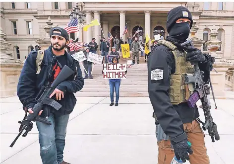  ?? FOTOS: AP ?? Bewaffnete Protestler in Lansing, Michigan. Die Frau im Hintergrun­d vergleicht Gouverneur­in Gretchen Whitmer (deren Namen sie falsch schreibt) mit Hitler.