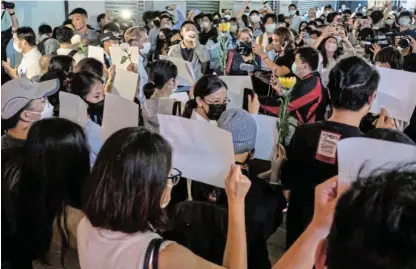  ?? /Anthony Kwan /Getty Images ?? Let’s start over: People hold up sheets of blank paper in protest against Covid-Zero restrictio­ns on the mainland in Hong Kong, China. During their own antiauthor­itarian protests students in the city used umbrellas as symbols.