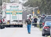  ?? MICHAEL WILSON/THE LAKELAND LEDGER ?? Polk County, Fla., Sheriff’s officials work the scene Sunday near Lakeland, Fla.