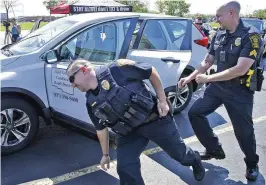  ?? BILL LACKEY / STAFF ?? During the “Quick Click Challenge,” four participan­ts are timed as they quickly change positions in a car and buckle their seat belts in each seat.