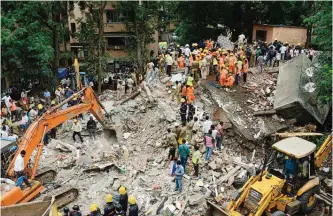  ?? —AFP ?? MUMBAI: Indian rescue workers look for survivors in debris at the site of a building collapse.