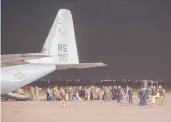  ?? VISAR KRYEZIU/AP ?? Families evacuated from Afghanista­n walk past a U.S Air Force plane Aug. 29 that they arrived on at Pristina Internatio­nal Airport in Kosovo.