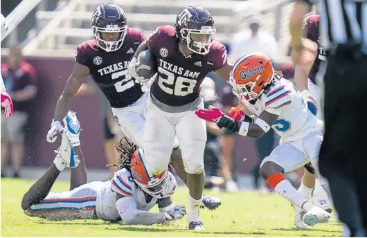  ?? Station, Texas. SAM CRAFT/AP ?? Texas A&M running back Isaiah Spiller (28) stiff-arms Florida defensive back Chester Kimbrough (25) on Saturday at Kyle Field in College