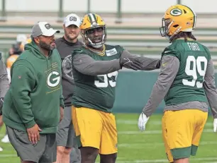  ?? MARK HOFFMAN/JOURNAL SENTINEL ?? Defensive line coach Jerry Montgomery works with Devonte Wyatt (95) and Jonathan Ford during rookie camp in May.