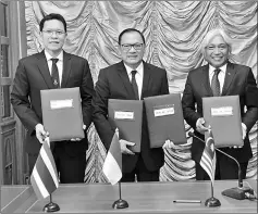  ??  ?? (From left) Veerathai, Agus DW Martowardo­jo, and Muhammad Ibrahim, posing for a group photo after signing the bilateral MoUs on local currency settlement framework. — Bernama photo