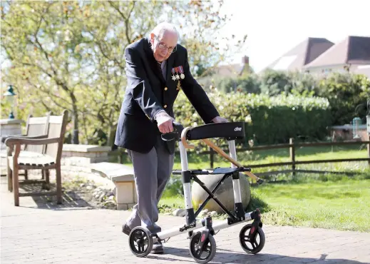  ??  ?? Retired British Army Captain Tom Moore walks to raise money for health workers, by attempting to walk the length of his garden 100 times before his 100th birthday in April last year in Marston Moretaine, Britain. — Reuters