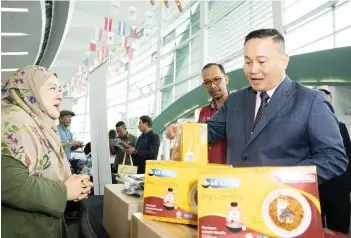  ?? — Photo by Chimon Upon ?? Willie (right) and Mohd Zaib (second right) seen speaking to one of the entreprene­urs who had set up a booth at the BCCK in conjunctio­n with the Maskop Madani programme.