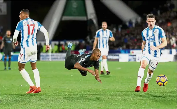  ?? — Reuters ?? Guilty: Manchester City’s Fernandinh­o is booked for simulation after this challenge by Huddersfie­ld’s Rajiv van La Parra (left) at the John Smith’s Stadium on Nov 26.