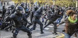  ?? SANTI PALACIOS / ASSOCIATED PRESS ?? Catalan riot police charge against demonstrat­ors as they try to approach the site where Spain’s Cabinet held a meeting Friday in Barcelona.