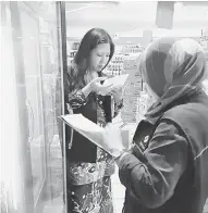  ??  ?? MENCUKUPI: Pegawai Pemantau Harga Rafidah Nudin sedang memeriksa bekalan barang keperluan semalam.