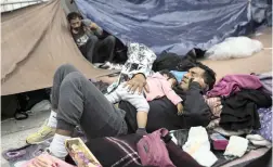  ?? PICTURE: AP ?? NO ROOM: A migrant father and child rest where they set up camp to wait for access to request asylum in the US, outside the El Chaparral port of entry building at the US-Mexico border in Tijuana, Mexico.