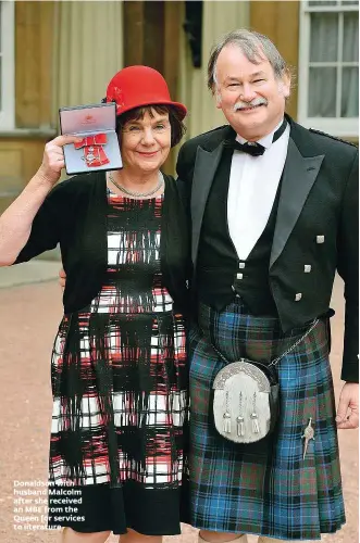  ??  ?? Donaldson with husband Malcolm after she received an MBE from the Queen for services to literature