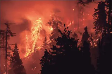  ?? Kyle Grillot / AFP via Getty Images ?? The Bobcat Fire continues to burn through the Angeles National Forest in California Sept. 17. More than two dozen major wildfires on the West Coast are sending smoke into the sky that can be seen across the country, including Connecticu­t.