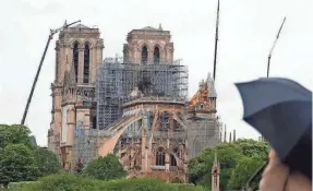  ?? THIBAULT CAMUS/AP ?? Workers have begun covering the roof, strengthen­ing the walls and salvaging what they can as planners debate the future of Notre Dame.