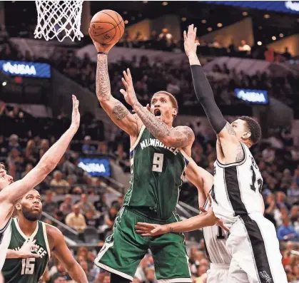  ?? SOOBUM IM / USA TODAY SPORTS ?? Bucks forward Michael Beasley goes up for a shot against Spurs guard Danny Green. Beasley had 28 points in the win in San Antonio.