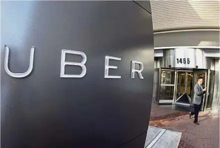  ??  ?? New system: A file picture shows a man leaving the headquarte­rs of Uber in San Francisco. Uber has started testing the route-based pricing in 14 US cities for months.