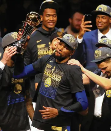  ?? GETTY IMAGES ?? Golden State’s Kevin Durant raises the NBA Finals MVP trophy after the Warriors swept the Cavaliers.