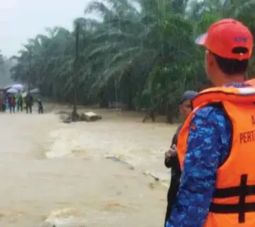  ?? ?? ANGGOTA Angkatan Pertahanan Awam (APM) melakukan pemantauan di lokasi banjir.