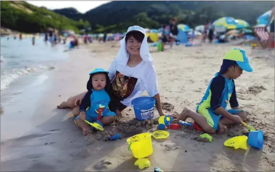  ?? PROVIDED TO CHINA DAILY ?? Hong Kong resident Candy Tang spends a day with her children at the beach. Tang said the pandemic brought her closer to her family.