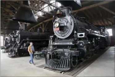  ?? MARVIN FONG ?? On April 15, Noel Poirier, executive director of the Age of Steam Roundhouse, walks near one of the facility’s locomotive­s in Sugarcreek, Ohio.