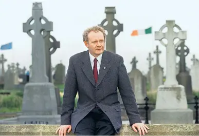  ??  ?? McGuinness at Dundalk cemetery awaiting the Easter Rising Remembranc­e Parade in 1999, and, below, with Gerry Adams at the funeral of an IRA member in 1987: during the Troubles he maintained that ‘God will understand the pressures we are under’