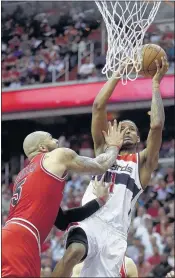  ?? BRIAN CASSELLA / MCCLATCHY NEWS SERVICE ?? Washington forward Trevor Ariza is fouled by Chicago forward Carlos Boozer during the second half of their first-round playoff game on Sunday. The Wizards won to take a 3-1 lead.