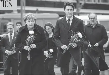  ?? ODD ANDERSEN / AFP / GETTY IMAGES ?? German Chancellor Angela Merkel and Prime Minister Justin Trudeau arrive Friday to lay flowers at a memorial to the victims of the Breitschei­dplatz Christmas market truck attack near the Kaiser Wilhelm Memorial Church in Berlin. The Dec. 19 attack...