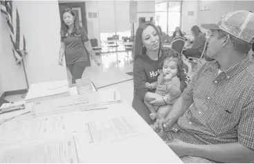  ?? Melissa Phillip / Houston Chronicle ?? Attorney Elizabeth Tran, with Boat People SOS, left, assists Genesis Villalpand­o and her husband, Erik, with his DACA renewal paperwork at a community event Saturday in Bellaire.