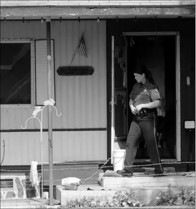  ?? Photograph by Michael Woods/nwa Media ?? Benton County Sheriff deputy Keshia Guyll looks over the scene of a house fire Tuesday, July 30, at the home of Eva Simpson in Pea Ridge. Simpson was killed in the fire. Simpson died of smoke inhalation.