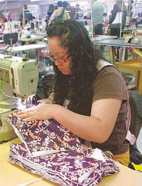 ?? /CUARTOSCUR­O ?? Una mujer realiza labores de costurera en una fábrica mexicana