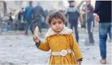  ?? ?? طفلة فلسطينية تحمل قطعة من الخبز فى ظل حصار إسرائيلى ضد غزة
