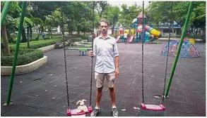  ?? — AFP ?? Painful separation: Emmanuel posing next to his child’s doll at the playground of Benjasiri park in Bangkok, where he used to take her.