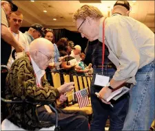  ?? Janelle Jessen/Siloam Sunday ?? Frank Thacker Jr., 92, of Fountain Hill, Ark., received an honor coin from his son, George Thacker of Darien, Conn., during the Oklahoma and Arkansas Honor Flight send-off ceremony on Tuesday evening. Frank served in World War II, the Korean War and...