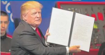  ?? | SCOTT OLSON/ GETTY IMAGES ?? President Donald Trump holds the executive order he signed in Kenosha on Tuesday.