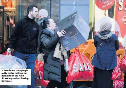  ??  ?? People out shopping in a city centre looking for bargains on the High Street in previous Boxing Day sales