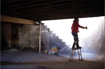  ?? NWA Democrat-Gazette/CHARLIE KAIJO ?? Finisher Agapito Sanchez of Reliable Dry Wall finishes sheet rock in a basement Thursday at the old Dollar Saver building in Rogers. Northwest Arkansas restaurant, coffee, bakery and other owners as well as Realtors and architect firms have partnered...