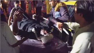  ?? Wakil Kohsar/AFP via Getty Images / Tribune News Service ?? Medical and hospital staff bring an injured man on a stretcher for treatment after two blasts, which killed at least 13 U.S. troops and wounded 60 Afghans, outside the airport in Kabul on Thursday.