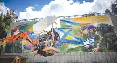  ?? (Yonatan Sindel/Flash90) ?? SOLDIERS paint a mural in Jerusalem last week ahead of Israel’s Remembranc­e Day on May 12-13.